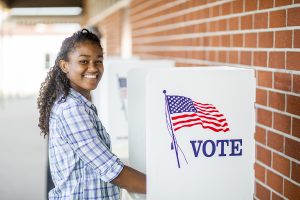 A young black girl voting on election day